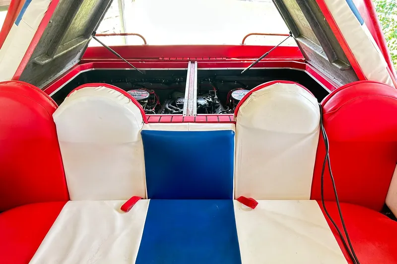 Slide: The Image of 1987 Chris-Craft 312 Stinger interior with red, white, and blue seating and visible engine compartment. - 42