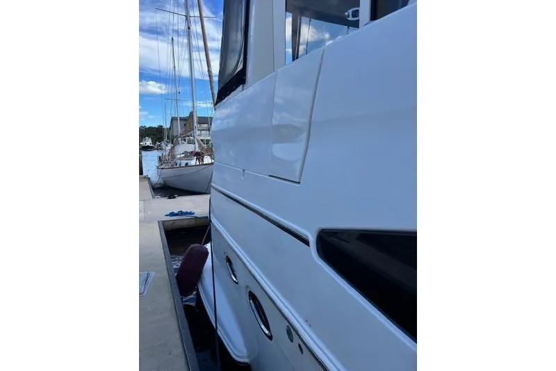 Slide: The Image of 2004 Carver 466 Motor Yacht docked near a bridge under a blue sky. - 12