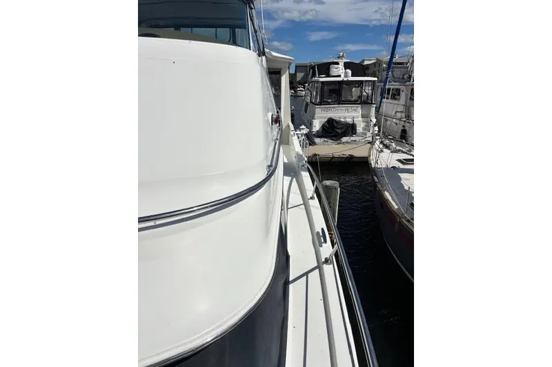 Slide: The Image of 2004 Carver 466 Motor Yacht docked under a clear blue sky. - 35