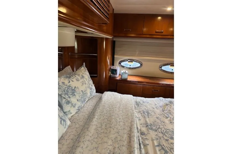 Slide: The Image of Luxurious interior of 2004 Carver 466 Motor Yacht with wood cabinetry and floral bedding. - 57
