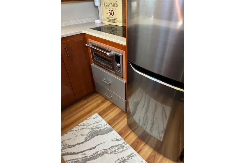 Slide: The Image of 2004 Carver 466 Motor Yacht kitchen with wood cabinetry and stainless steel appliances. - 62