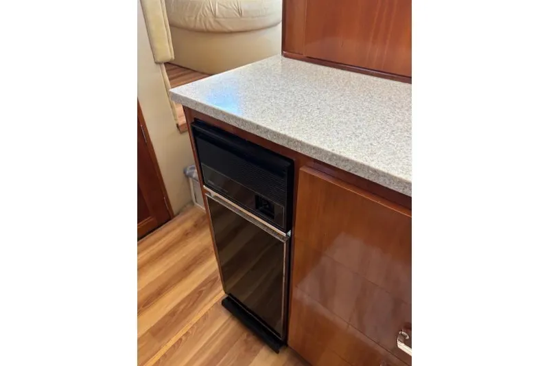 Slide: The Image of Stainless steel refrigerator in 2004 Carver 466 Motor Yacht interior, featuring wood accents. - 66