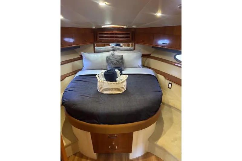 Slide: The Image of Interior of 2004 Carver 466 Motor Yacht bedroom with porthole, bed, and storage cabinets. - 77