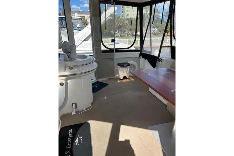 Slide: The Image of Interior of 2004 Carver 466 Motor Yacht with wooden table and marina view. - 16