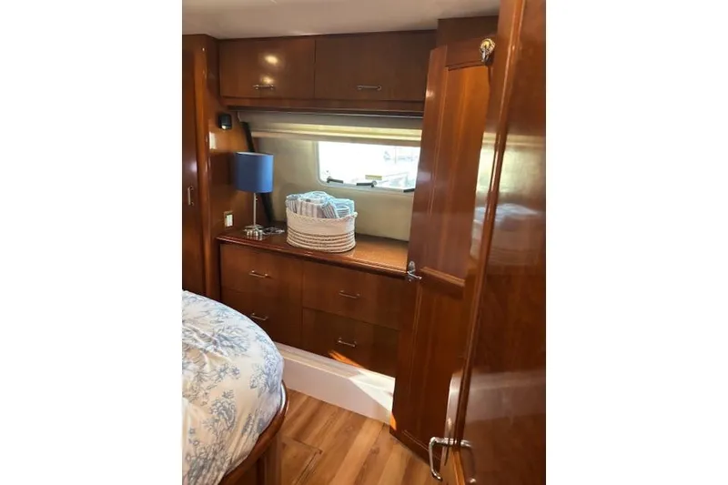 Slide: The Image of Luxurious bedroom interior of 2004 Carver 466 Motor Yacht with floral bedding and porthole windows. - 47