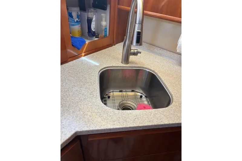 Slide: The Image of 2004 Carver 466 Motor Yacht kitchen with stainless steel fridge, microwave, and wooden cabinetry. - 63