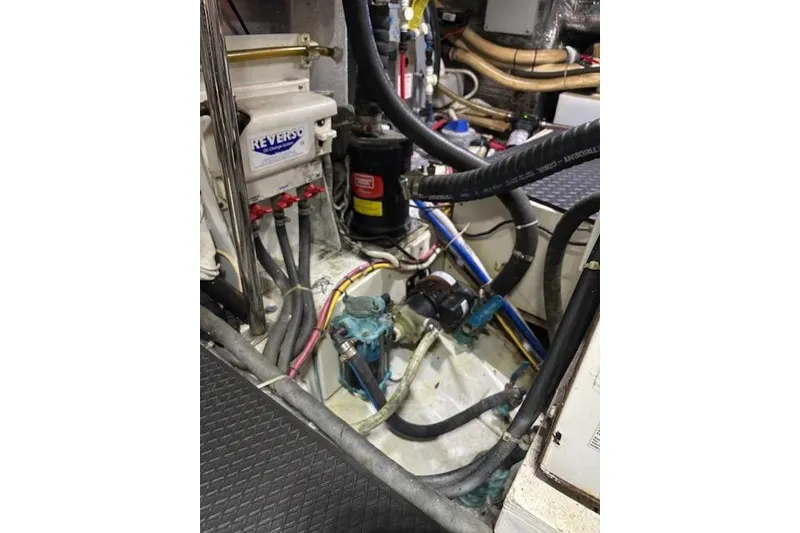 Slide: The Image of Engine compartment of a 2004 Carver 466 Motor Yacht, showcasing mechanical components and hoses. - 90