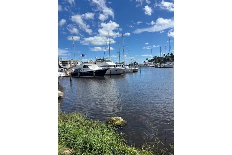 Slide: The Image of 2004 Carver 466 Motor Yacht docked in a sunny marina with blue skies. - 97