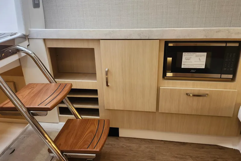 Slide: The Image of Modern kitchen area in 2026 Regal 38 SAV boat with microwave and wooden steps. - 20