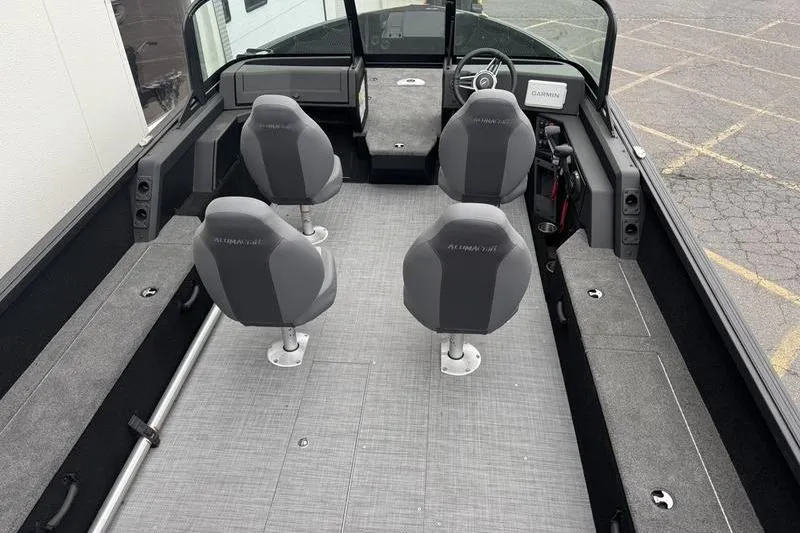 Slide: The Image of 2025 Alumacraft Competitor 205X Sport boat interior with four gray seats and steering console. - 5
