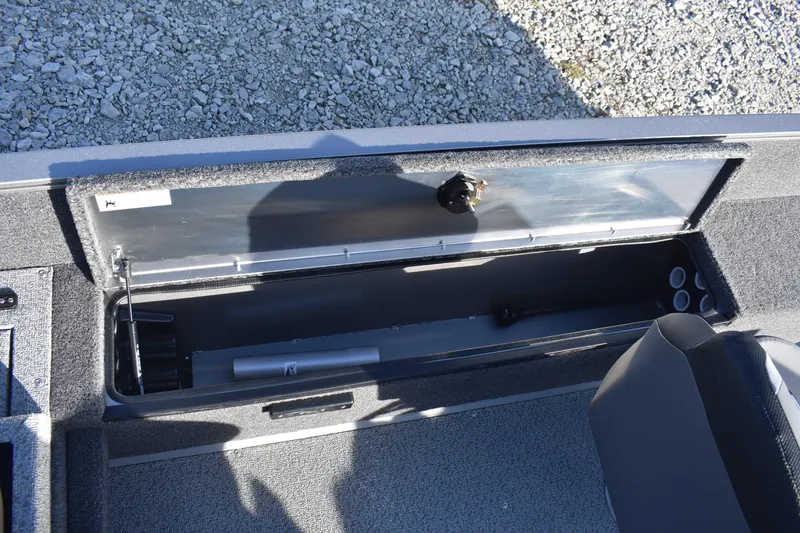 Slide: The Image of 2026 Lowe Fishing Machine 1675SC storage compartment with open lid, showing interior details. - 13