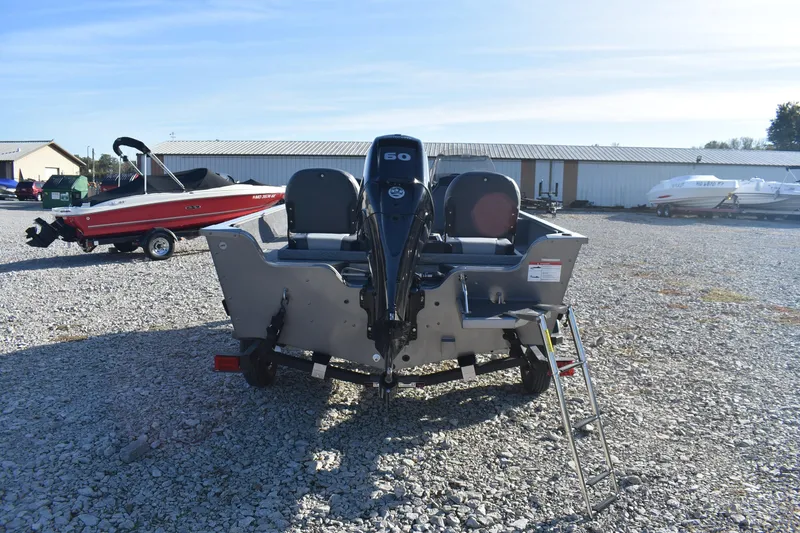 Slide: The Image of 2026 Lowe Fishing Machine 1675SC boat with outboard motor on gravel lot. - 4