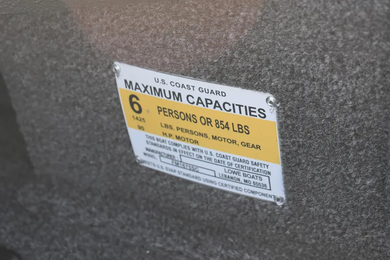 Slide: The Image of 2026 Lowe Fishing Machine 1675SC capacity label, 6 persons or 854 lbs, U.S. Coast Guard compliant. - 9