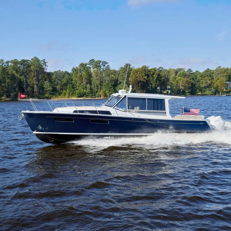 The Image of 2026 MJM 47R yacht cruising on a scenic lake with forested shoreline. - 0