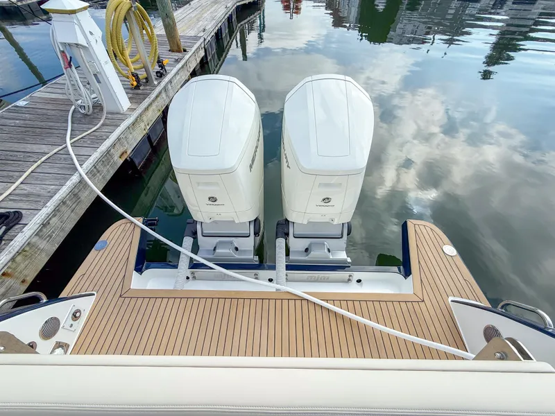Slide: The Image of Twin Mercury outboard engines on a 2026 MJM 47R boat at a dock. - 24