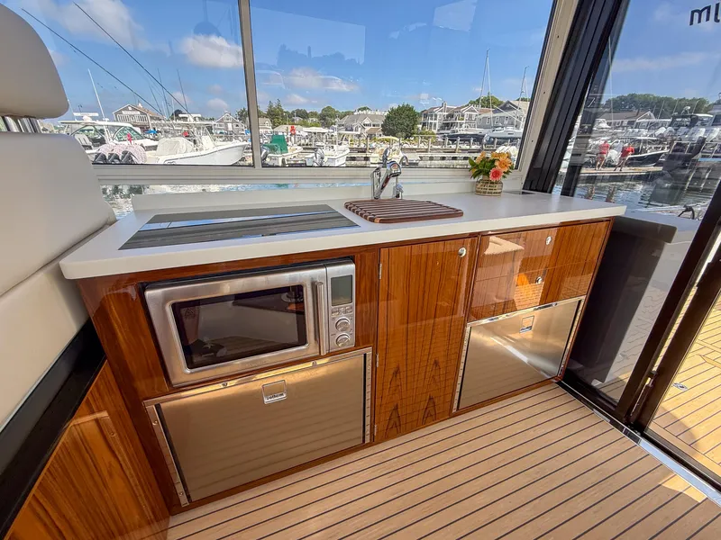 Slide: The Image of Luxurious 2026 MJM 47R yacht interior with modern kitchenette and scenic marina view. - 7