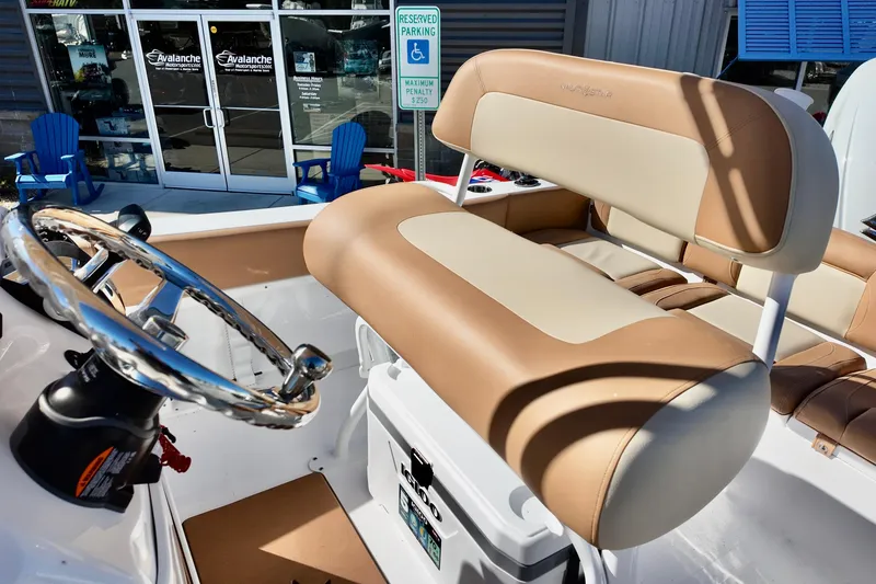 Slide: The Image of 2026 NauticStar 212 Legacy boat interior with tan seating and steering wheel. - 12