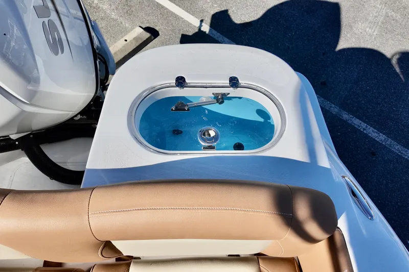 Slide: The Image of 2026 NauticStar 212 Legacy boat livewell with blue interior and engine detail. - 17