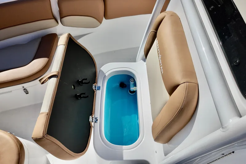 Slide: The Image of 2026 NauticStar 212 Legacy boat interior with open storage compartment and cushioned seating. - 19
