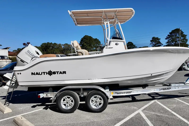 Slide: The Image of 2026 NauticStar 212 Legacy boat on trailer, featuring Suzuki outboard motor. - 5