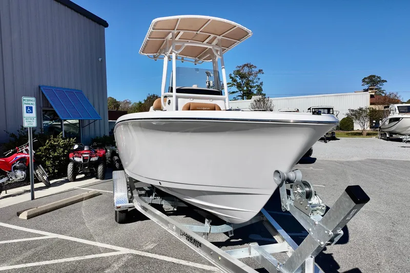 Slide: The Image of 2026 NauticStar 212 Legacy boat on trailer, parked outdoors near a building. - 6