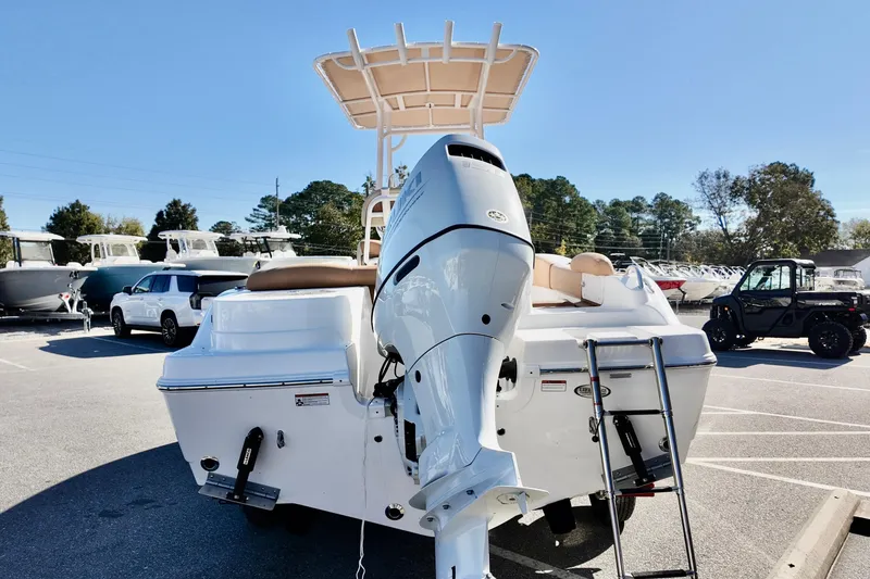 Slide: The Image of 2026 NauticStar 212 Legacy boat with outboard motor and ladder in a parking lot. - 7