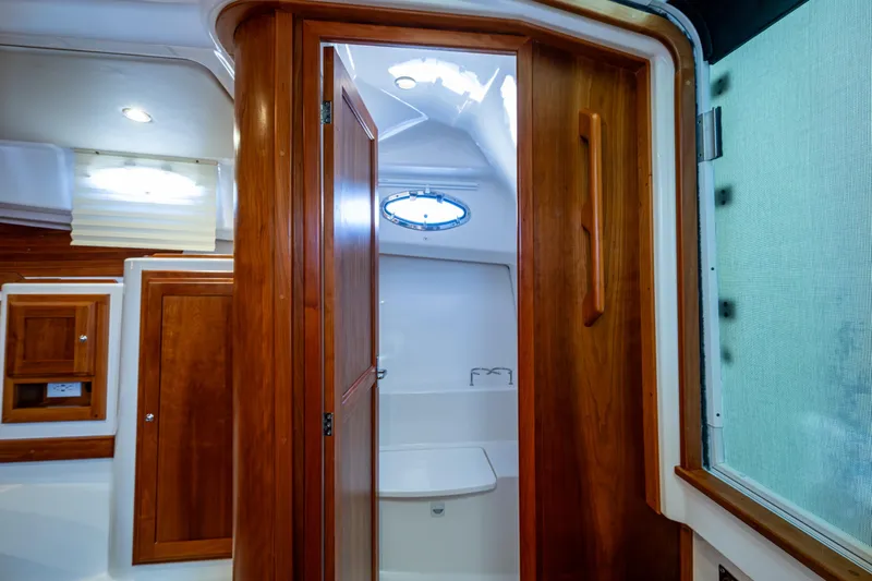 Slide: The Image of 2020 Back Cove 340 interior with wooden cabinetry and porthole window. - 12