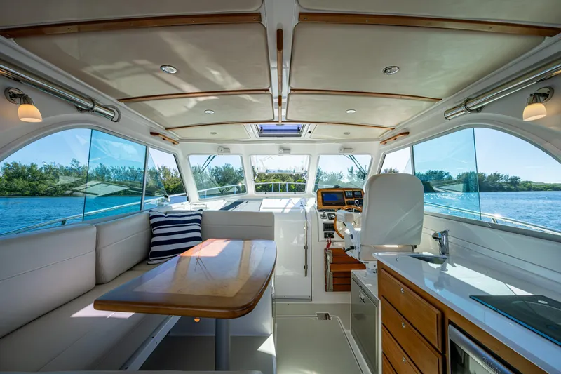 Slide: The Image of Interior of 2020 Back Cove 340 yacht with seating, table, and helm, overlooking water. - 15
