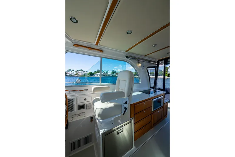 Slide: The Image of Interior of 2020 Back Cove 340 boat with helm seat and cabinetry, overlooking water. - 19