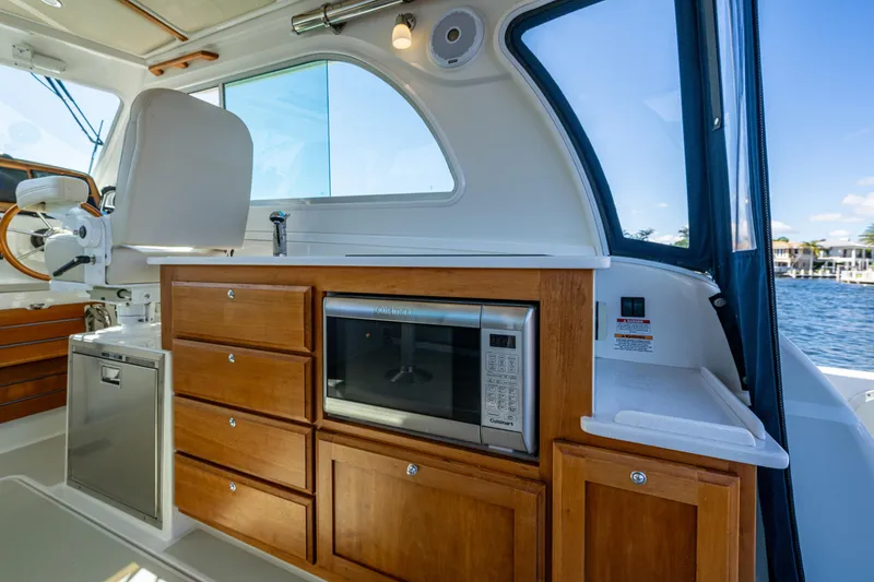 Slide: The Image of 2020 Back Cove 340 boat interior with wooden cabinetry and microwave. - 20
