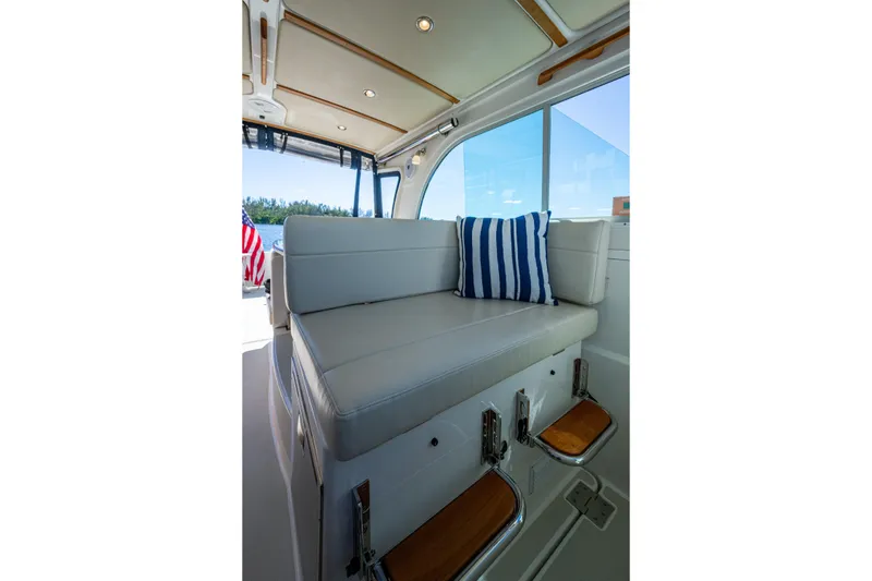 Slide: The Image of Interior of 2020 Back Cove 340 boat with cushioned seating and striped pillow. - 34