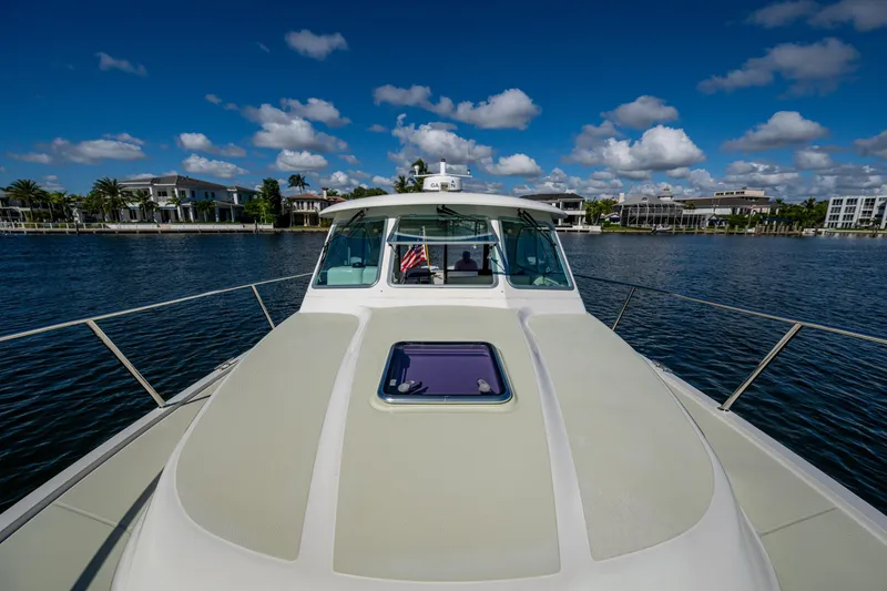 Slide: The Image of 2020 Back Cove 340 yacht cruising on a sunny day with waterfront homes in the background. - 4