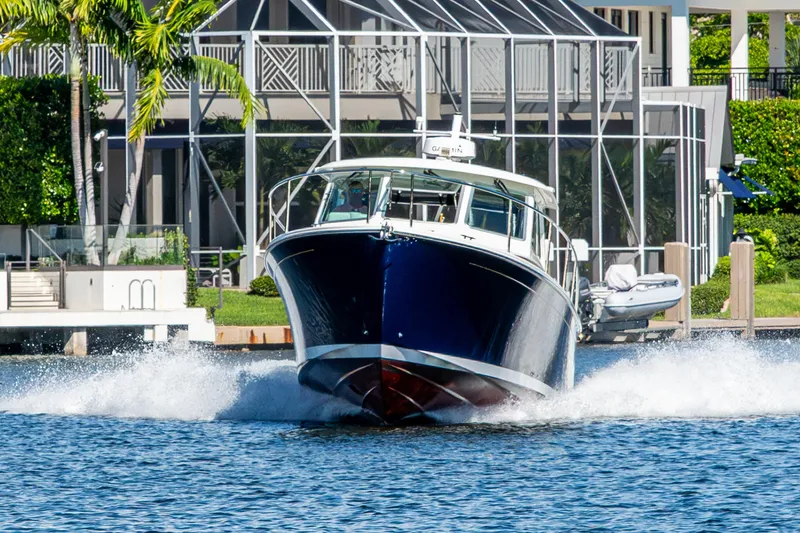 Slide: The Image of 2020 Back Cove 340 boat cruising on water near waterfront property. - 61