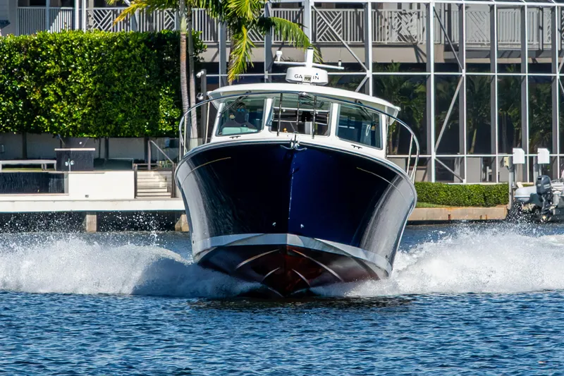 Slide: The Image of 2020 Back Cove 340 boat cruising on water near waterfront buildings. - 62