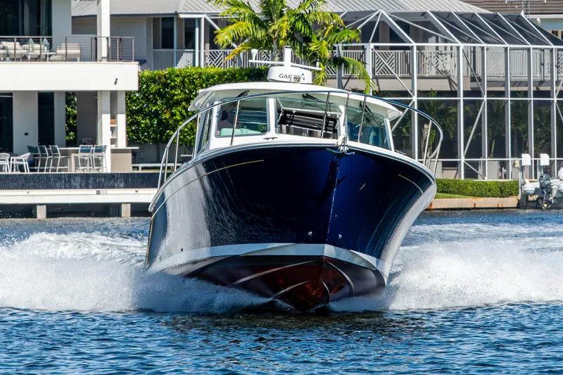 Slide: The Image of 2020 Back Cove 340 boat cruising on water near waterfront homes. - 65