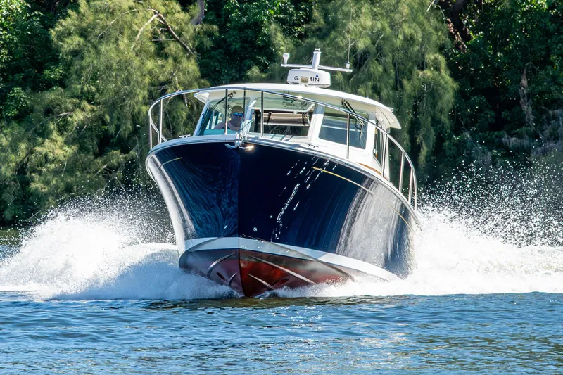 Slide: The Image of 2020 Back Cove 340 boat cruising on water with lush greenery background. - 70