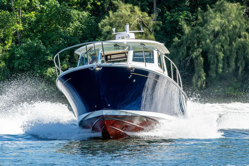 Slide: The Image of 2020 Back Cove 340 boat cruising on water with lush greenery background. - 71
