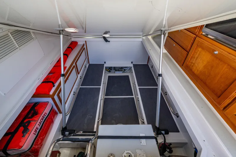 Slide: The Image of 2020 Back Cove 340 interior storage with life jackets and wooden cabinets. - 77