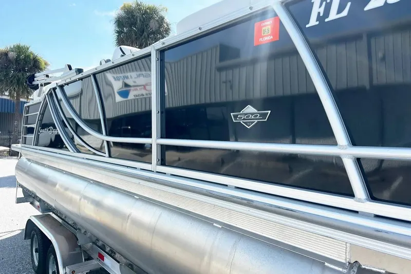Slide: The Image of 2023 South Bay 523 R pontoon boat on trailer, Florida registration visible. - 5