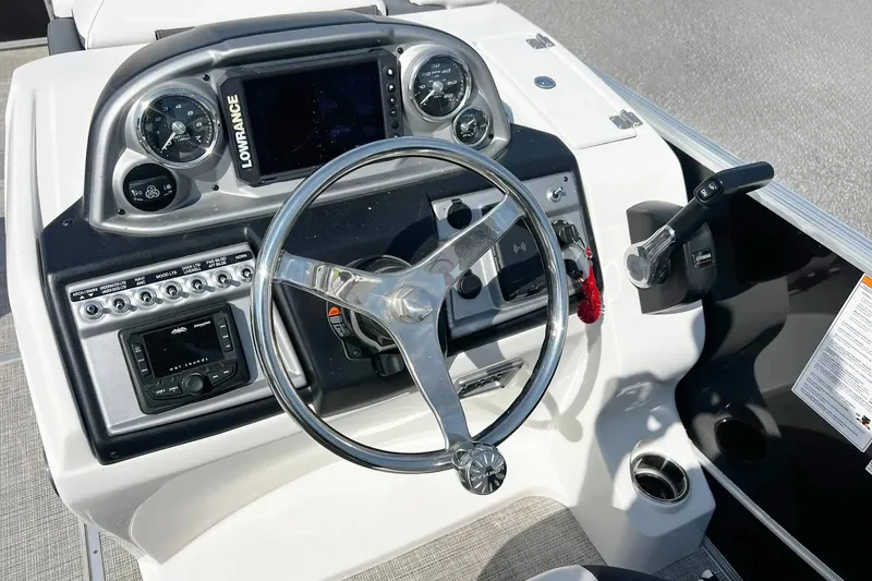 Slide: The Image of 2023 South Bay 523 R boat dashboard with steering wheel and control panel. - 9