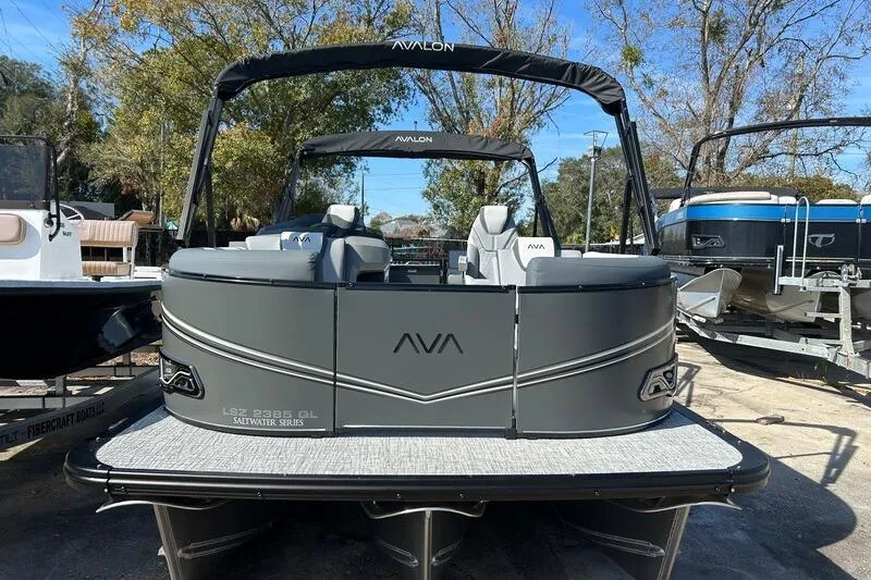 Slide: The Image of 2025 Avalon LSZ Quad Lounger pontoon boat, gray exterior, parked outdoors. - 5