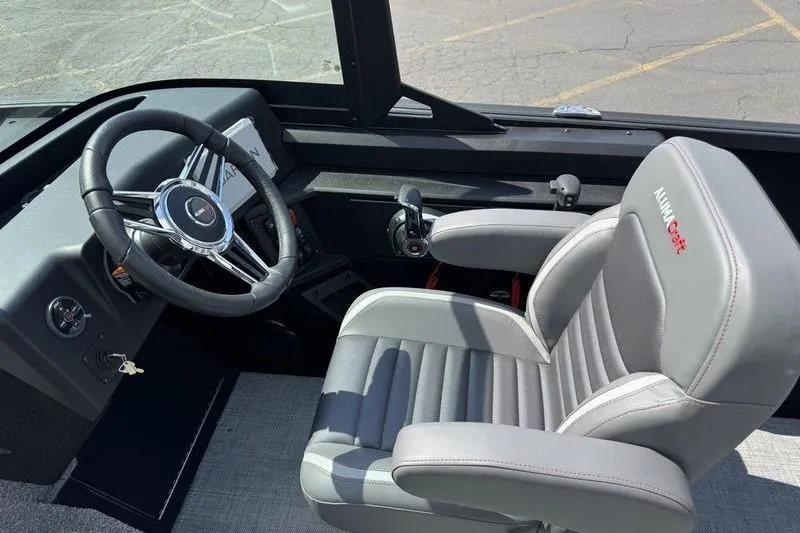 Slide: The Image of 2025 Alumacraft Competitor 185X Sport boat interior with steering wheel and cushioned seat. - 7
