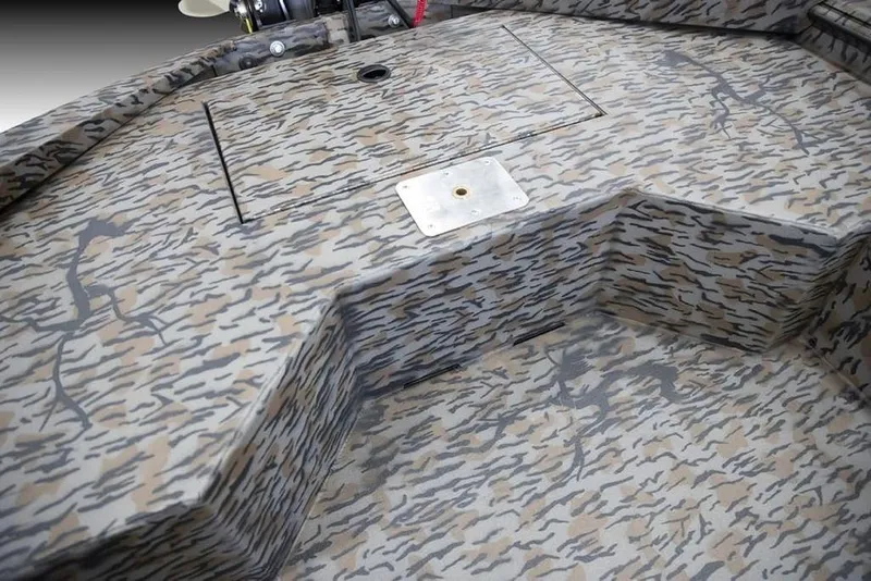 Slide: The Image of Camouflage interior of 2026 Xpress X18DB boat, featuring textured flooring and storage compartment. - 12