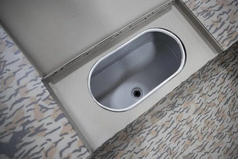 Slide: The Image of Built-in storage compartment on 2026 Xpress X18DB boat with camo-patterned flooring. - 18