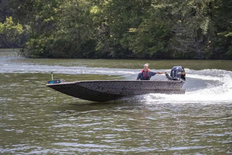 Slide: The Image of 2026 Xpress X18DB boat speeding on a lake with lush green trees in the background. - 6