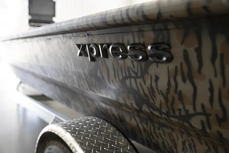 Slide: The Image of 2026 Xpress X18DB boat with camouflage design and logo detail. - 8