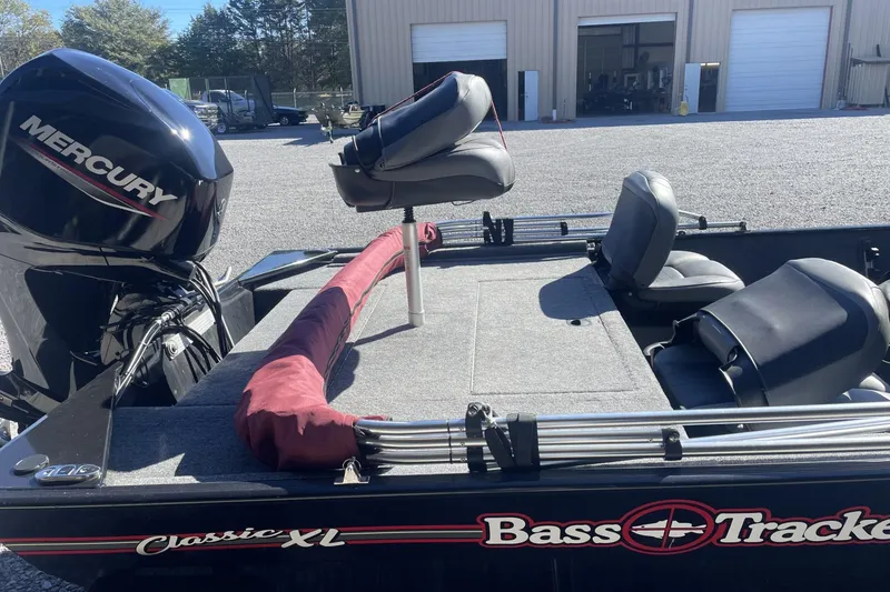 Slide: The Image of 2024 Bass Tracker Classic XL boat with Mercury engine, parked outdoors. - 5