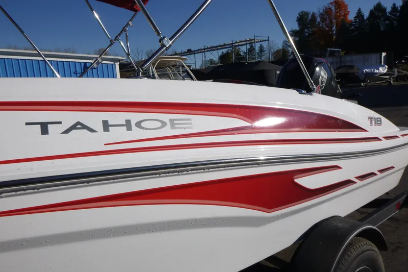Slide: The Image of 2024 Tahoe T18 boat with red and white design, parked outdoors. - 3