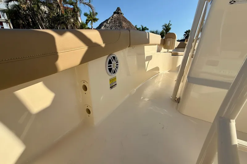 Slide: The Image of 2025 Scout 215 XSF boat interior with beige seating and speaker, under clear blue sky. - 18