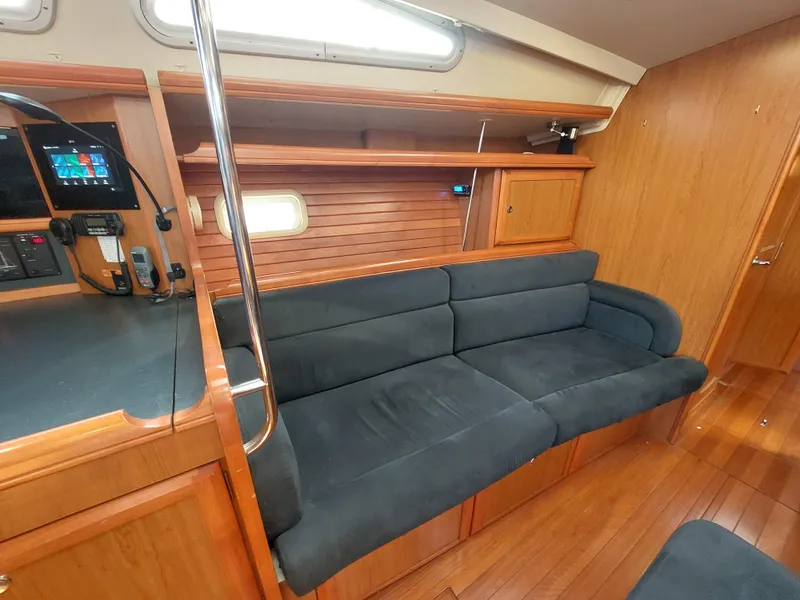 Slide: The Image of 2009 Hunter 49 yacht interior with wooden finish and black sofa. - 10
